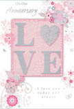 This anniversary card is portrayed as a gentle celebration of enduring romance, its overall impression one of softness and quiet depth. At the centre, the word LOVE is formed in elevated lettering dusted with a soft coat of glitter, so that the letters appear velvety to the eye and slightly rough to the touch. In place of a standard O, a shimmering silver heart nestles between the other letters, its textured surface catching the light a little more brightly, making it the emotional focal point of the card. Around this central word, delicate blossoms in blush pink and muted mauve unfurl with a watercolor delicacy, their edges softened and their colours subtly blended into the pale background. The flowers and leaves are drawn with slender, flowing lines, echoing the graceful shapes of stems thoughtfully arranged in a romantic bouquet delivered to a home near Crouch End. Fine, looping swirls and tiny accent details-petals, scattered dots, and understated butterfly silhouettes-add a sense of light motion, suggesting the whisper of a breeze moving through an English spring garden. The primary sentiments, including On Our Anniversary and I love you today and always, are written in a refined, understated script that winds gently around the floral design without overpowering it. The script has a hand-lettered feeling, like words penned slowly in a much-kept journal. The colour palette of soft pinks, silvery greys, and creamy whites keeps the composition soothing and intimate. Overall, the card radiates a sense of cherished partnership and thoughtful celebration, offering a paper keepsake as tender and expressive as a hand-picked bouquet from a trusted Hornsey florist.